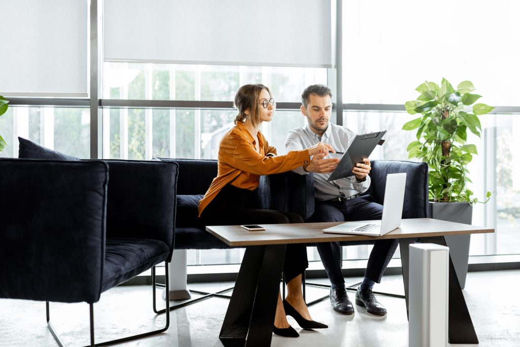 Zwei Business-Personen besprechen Unterlagen in einem modernen Büro – professionelle Zusammenarbeit, Teamwork und produktives Arbeitsumfeld